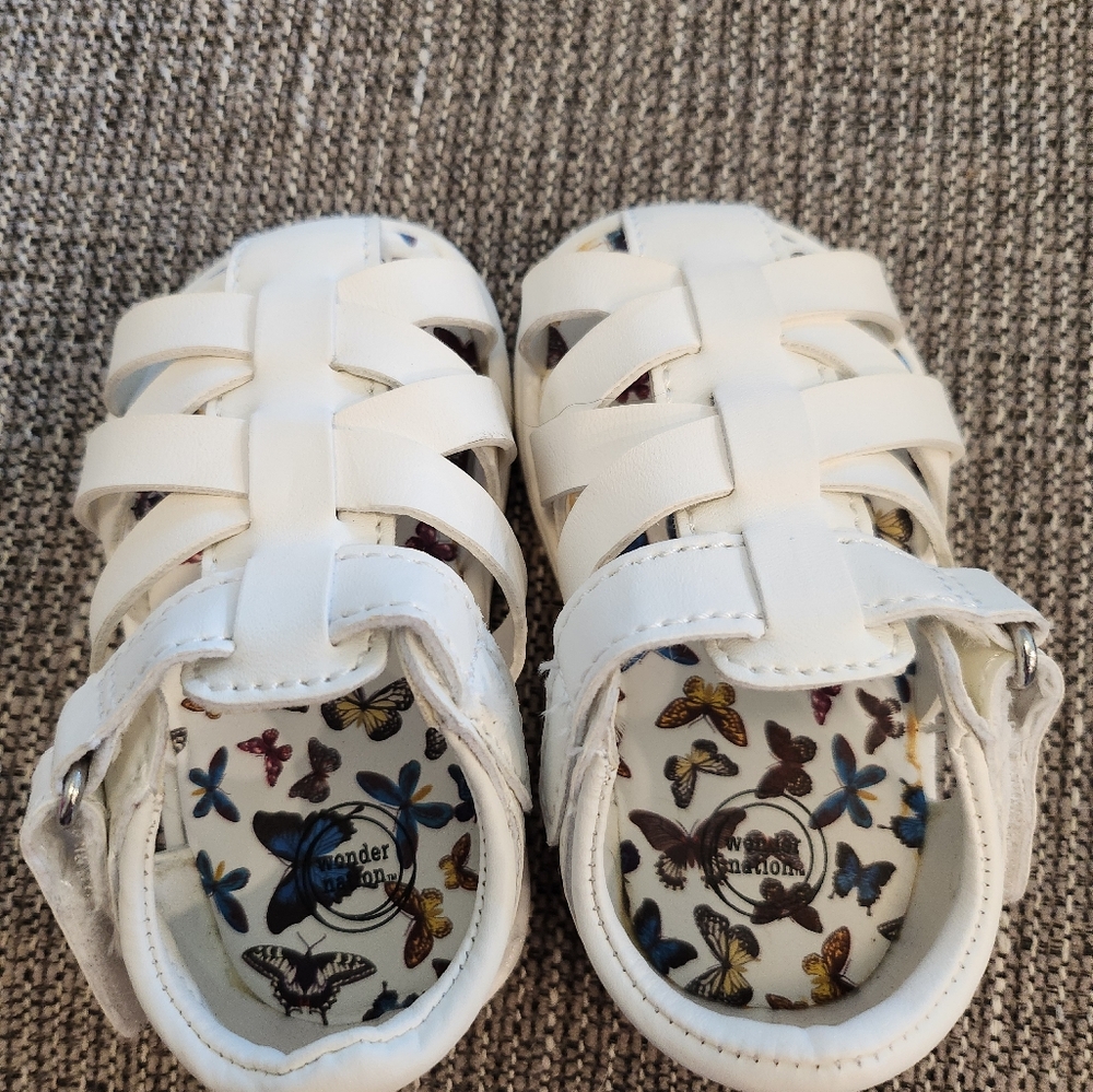 White sandals. Criss-cross design with velcro strap. Toddler sized 2